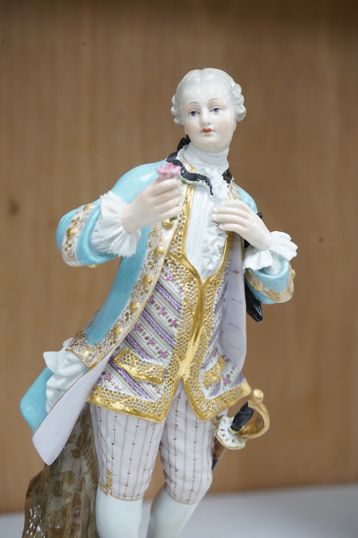 A Meissen figure of a gentleman holding a rose, 19th century, incised model number A58, 19cm high